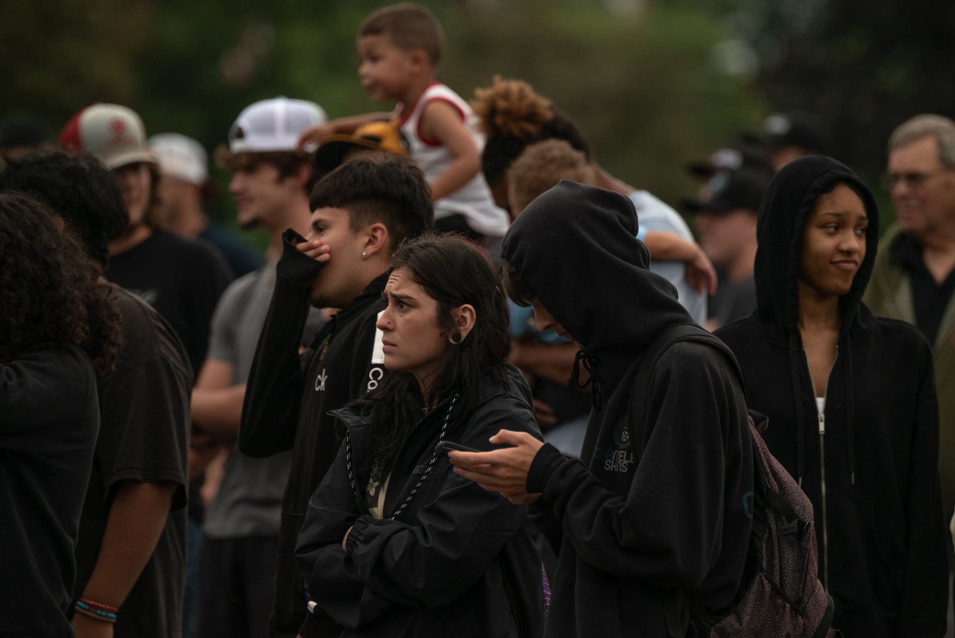 A diverse group of people gathered outdoors, captured in a thoughtful moment.