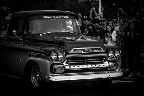 Free Black and white photo of a vintage Chevrolet truck in a city parade with a crowd in the background. Stock Photo