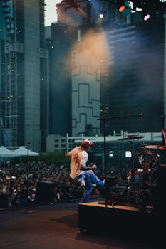 Energetic live music performance in a city setting with vibrant crowd.