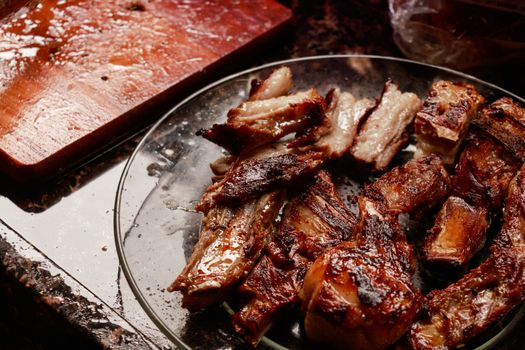 Close-up of mouth-watering grilled meat served on a glass plate, fresh from the barbecue.