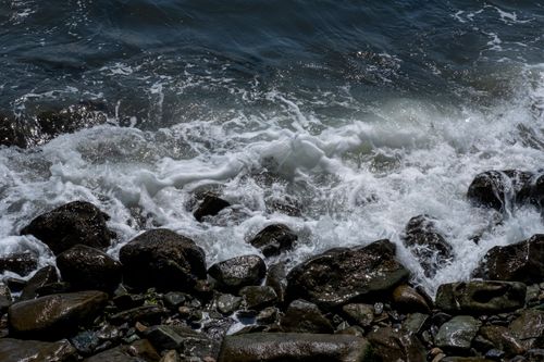 Free Captivating close-up of ocean waves crashing against rugged rocky shore, showcasing nature's power. Stock Photo