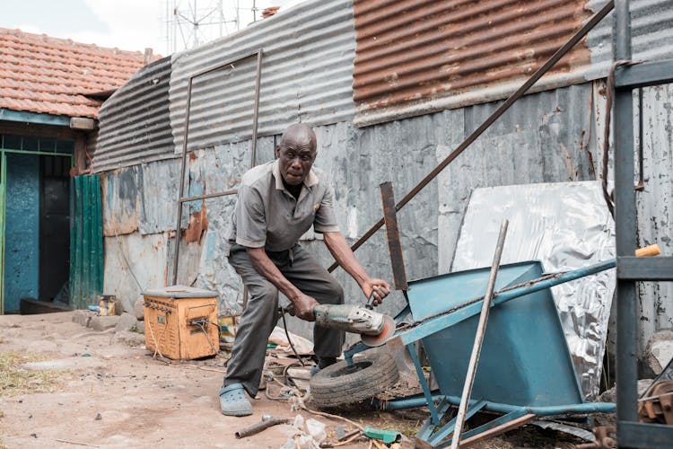 Man Working On A Wheelbarrow In The Yard