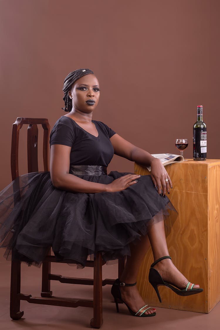 Portrait Of Woman Sitting In Studio With Wine