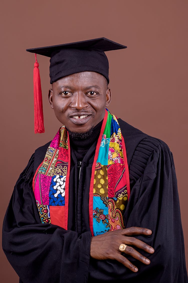 Portrait Of Man In Graduation Mantle In Studio