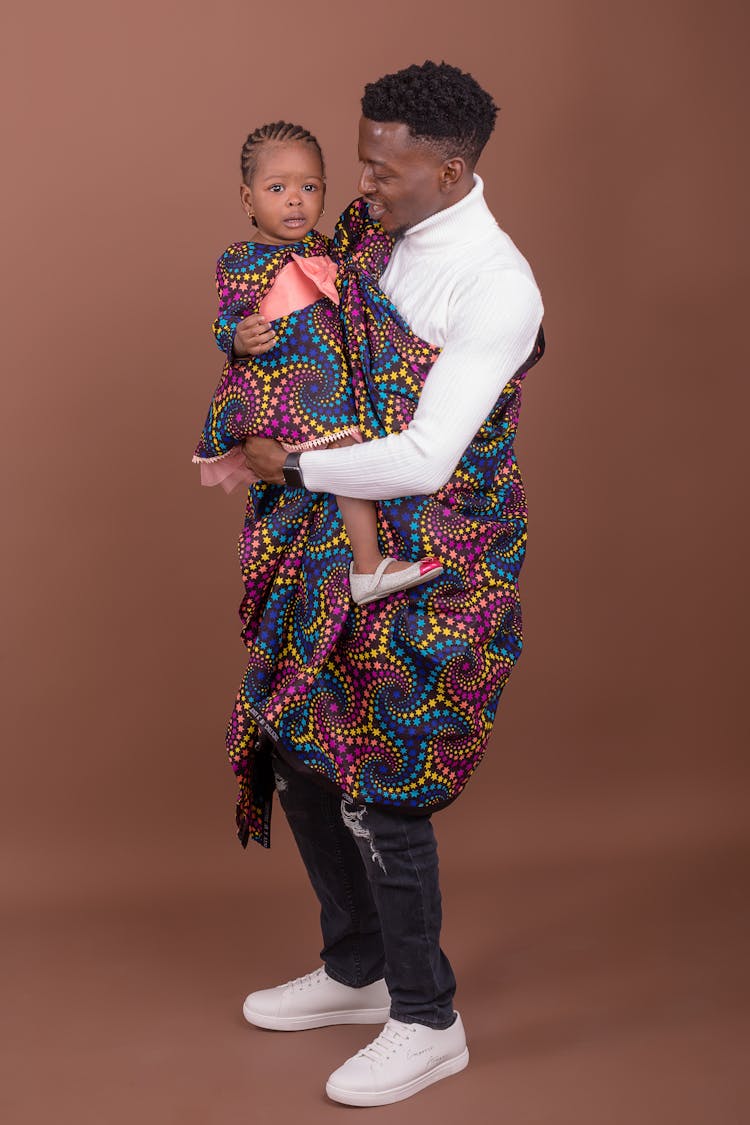 Man With Child In Clothes With Traditional Elements