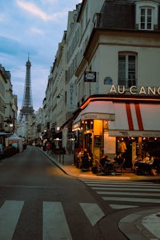 Vibrant Paris street scene at twilight featuring a cozy cafe and the iconic Eiffel Tower in the background.