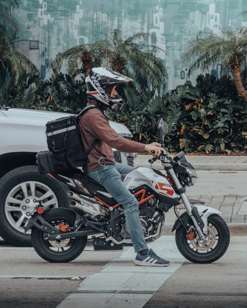 Man in Brown Long Shirt Riding a Motorcycle