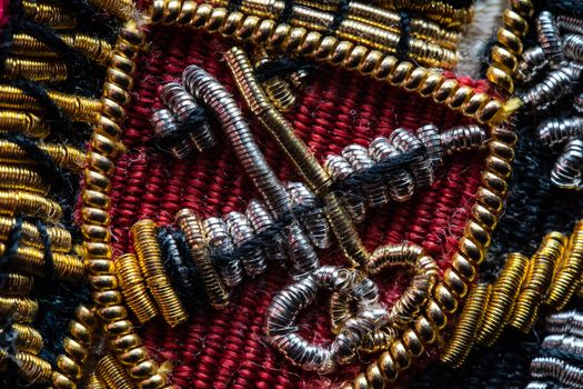 Intricate beaded embroidery with metallic threads and vibrant colors in close-up view.
