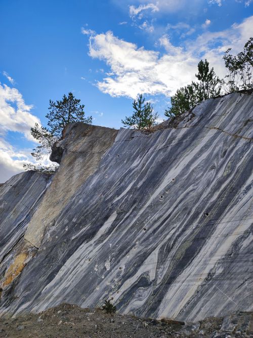 Free A striking marble cliff with trees set against a vibrant blue sky, showcasing natural beauty. Stock Photo