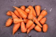 深色表面上，新鲜有机胡萝卜的顶视图突出了它们充满活力的橙色