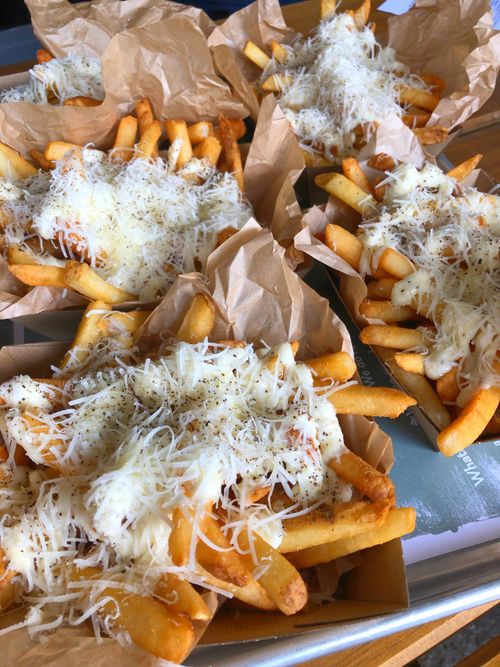 Free Crispy french fries topped with melted cheese and pepper served in Melbourne. Stock Photo