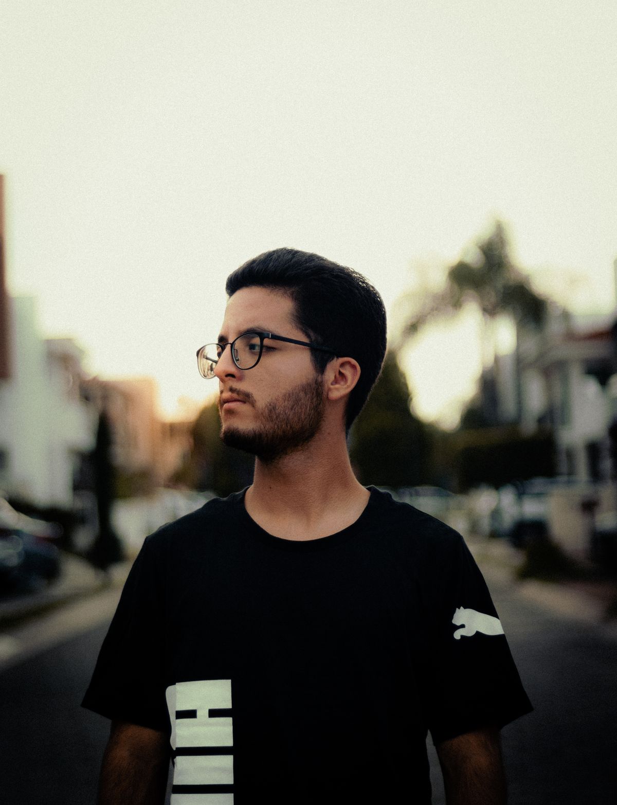 Man wearing a black crew-neck tee on a city street