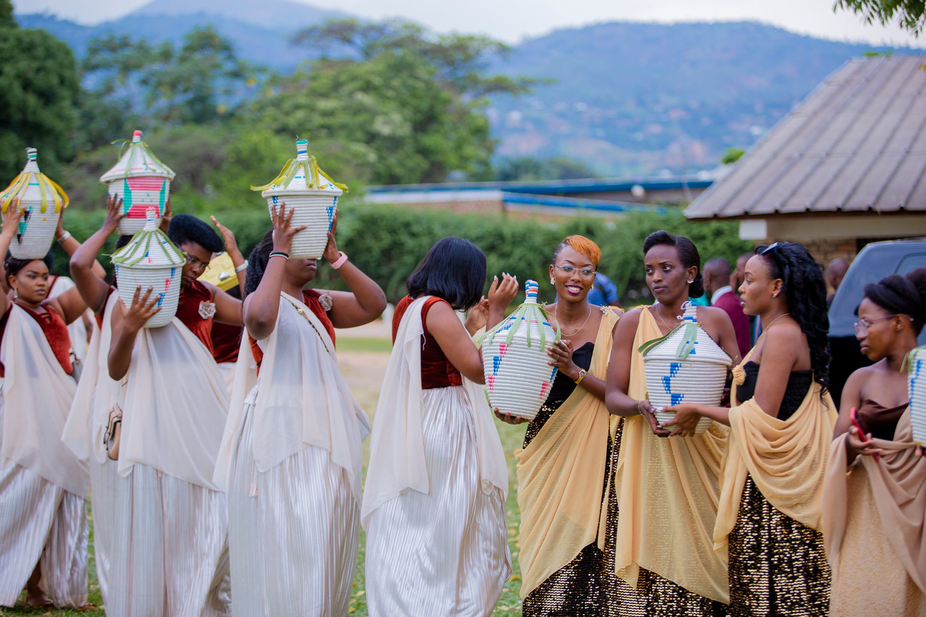 Women participating in a vibrant traditional ceremony, carrying colorful ceramic jars outdoors.