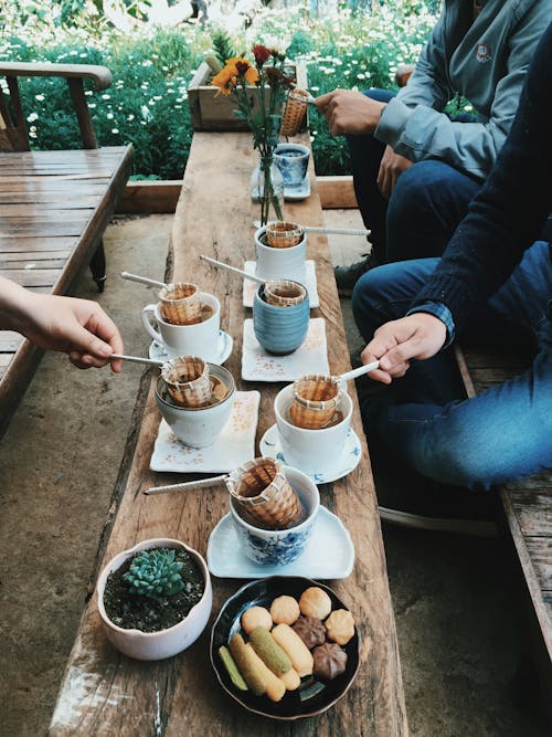 Three Person Holding Wicker Baskets With Handles in White Pots