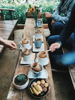Enjoying traditional Vietnamese coffee with snacks in a garden setting, capturing community and culture.