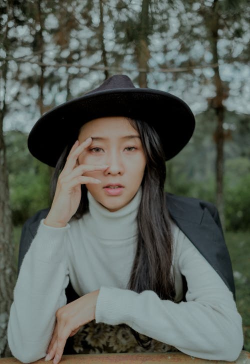 Woman in White Turtleneck Sweater Wearing Black Hat 