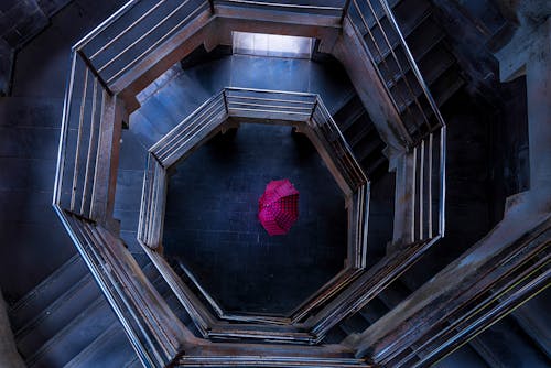 Селективная цветная фотография красного зонта в здании