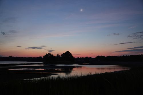 Free Scenic twilight view of a serene lake at Stamford, Connecticut, showcasing tranquil reflections and a crescent moon. Stock Photo