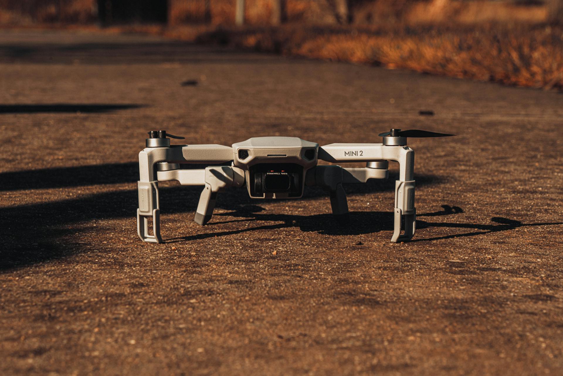 A close-up of a DJI Mavic Mini 2 drone on pavement, highlighting modern aerial technology.