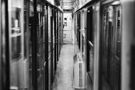 空荡火车车厢走廊的单色景观，突显了旅途的孤寂