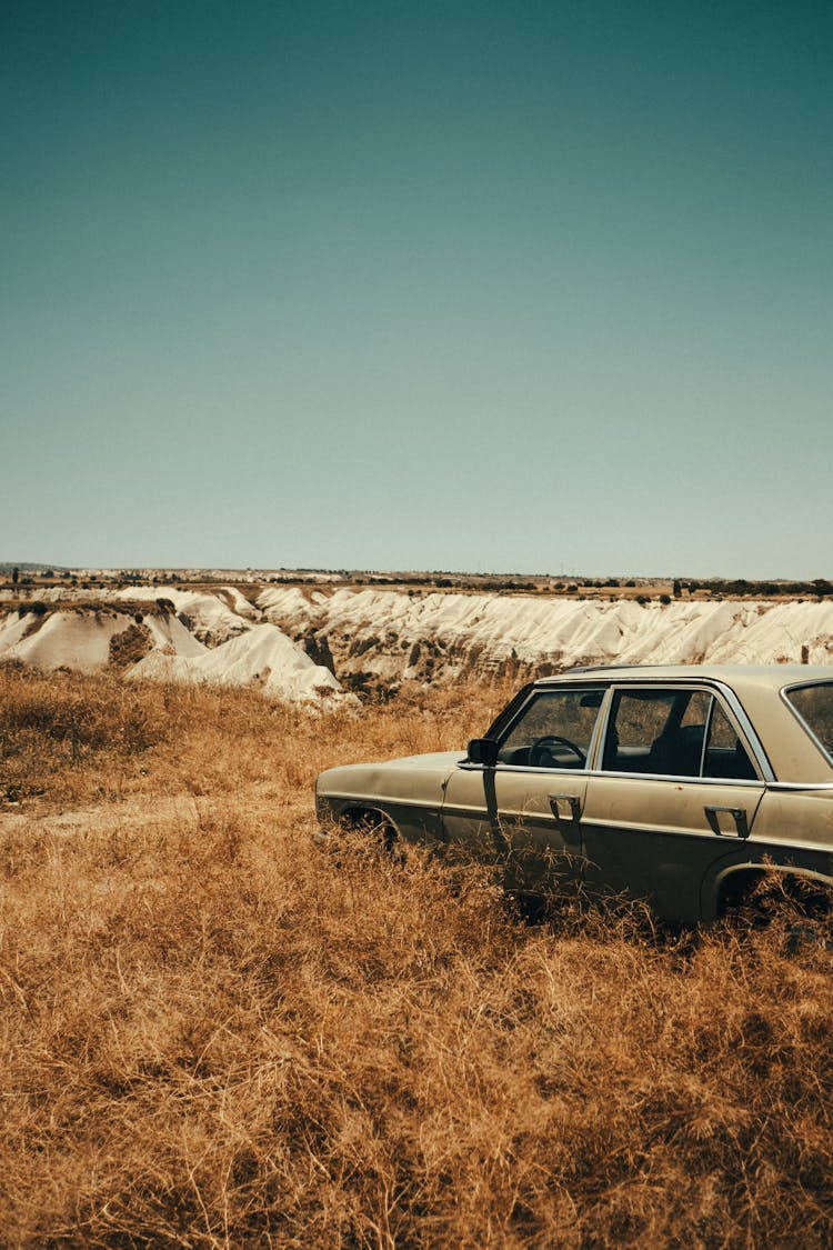 Car Parked On Brown Grass Field