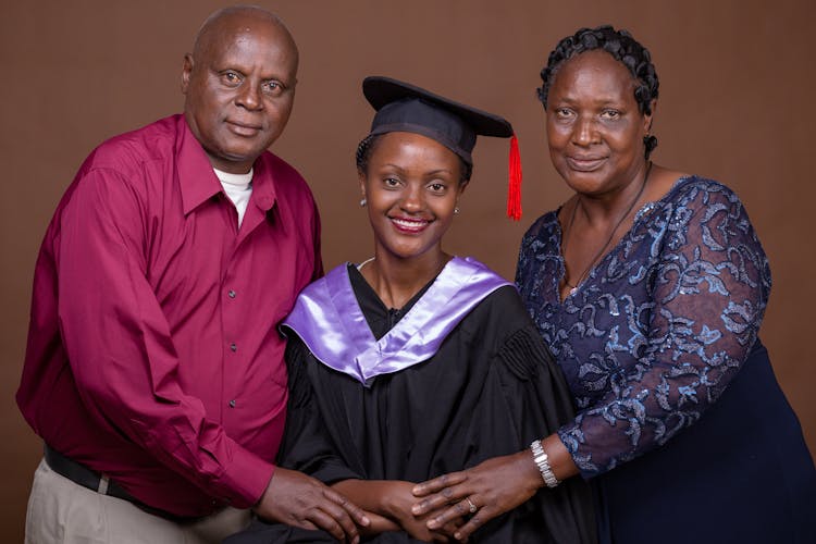 Parents And Her Daughter In A Graduation Gown 