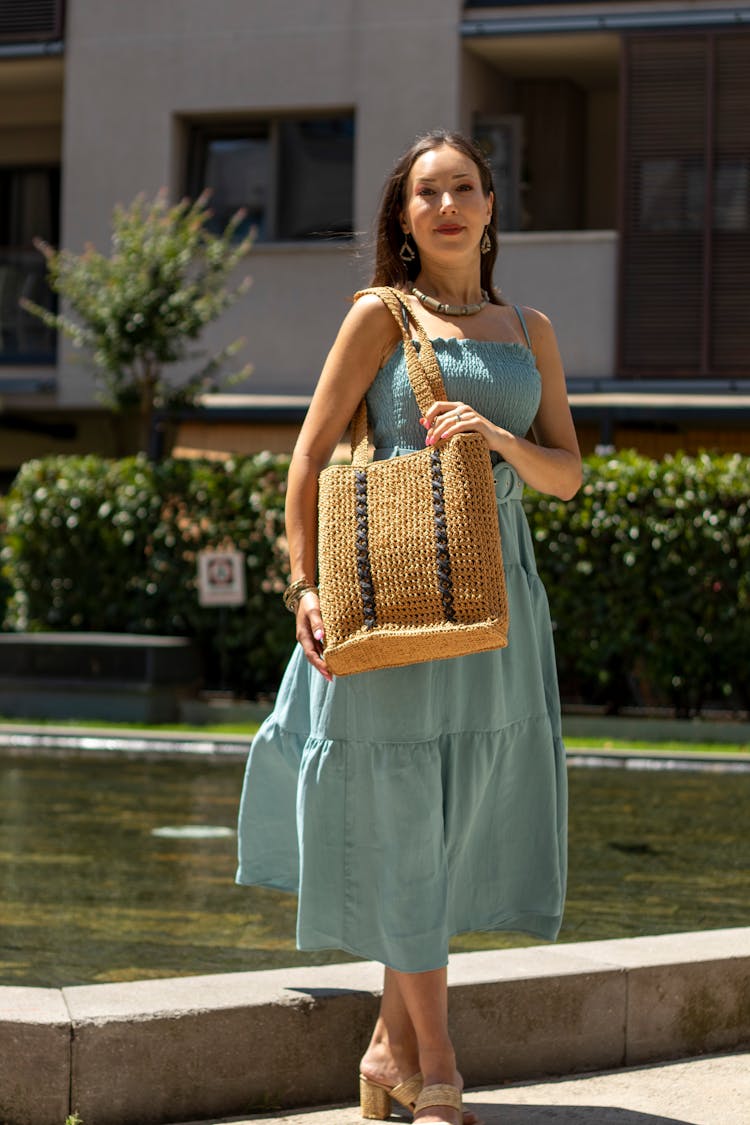 Woman With A Handbag Wearing A Blue Dress