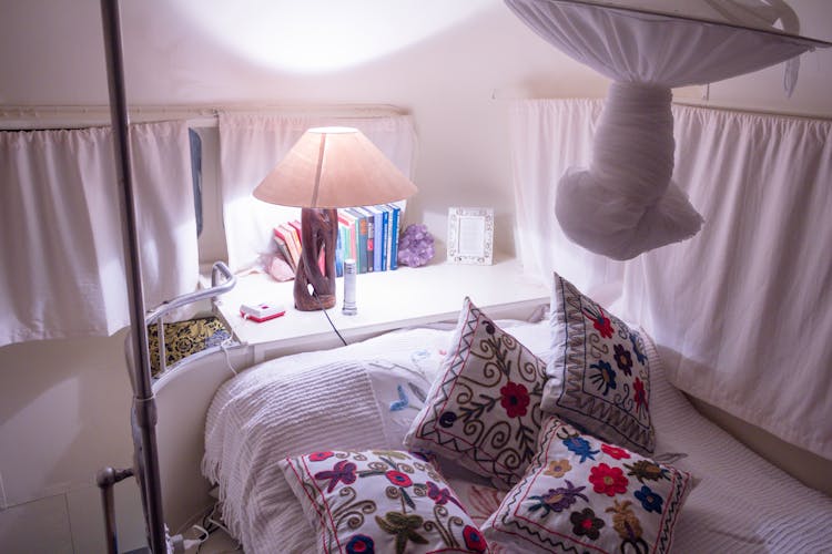 White And Red Floral Throw Pillows On White Bed