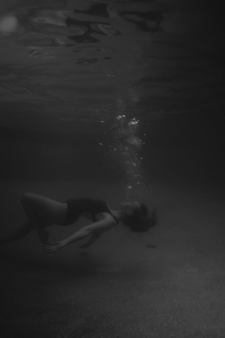 Black And White Photo Of A Woman In A Swimsuit Swimming Underwater