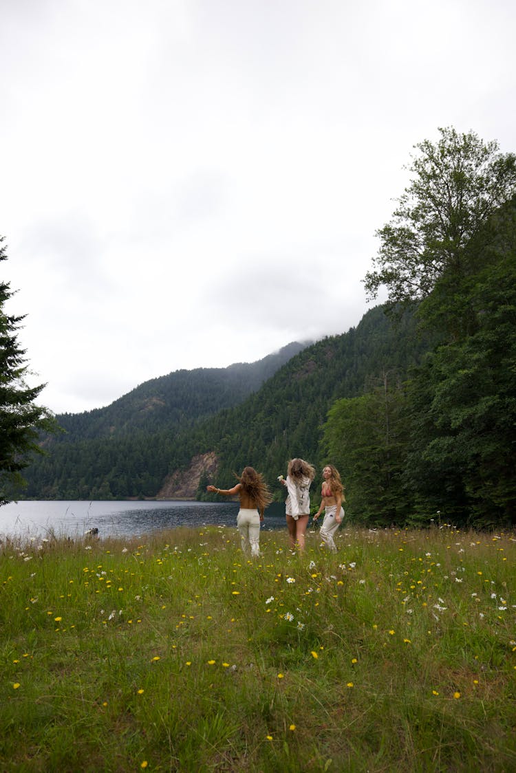 Three Women Running On Flower Field