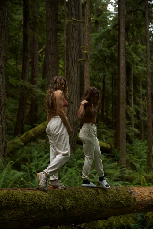 Two Women Wearing White Pants in the Forest