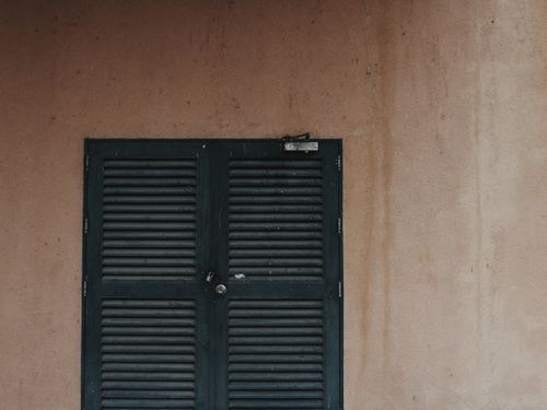 Free Rustic green door on weathered wall with urban vibe, showcasing age and character. Stock Photo