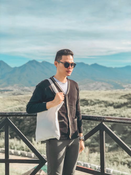 Man in Black Cardigan Holding a Tote Bag