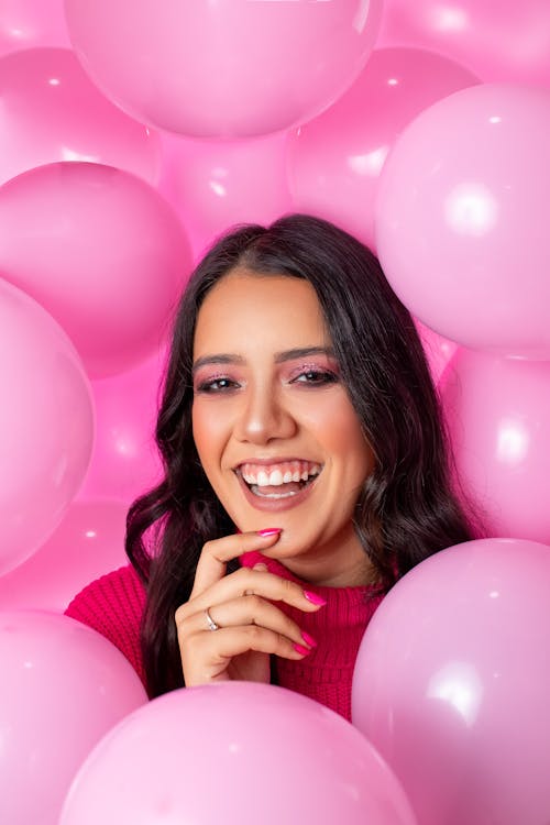Smiling Woman Surrounded by Pink Balloons 