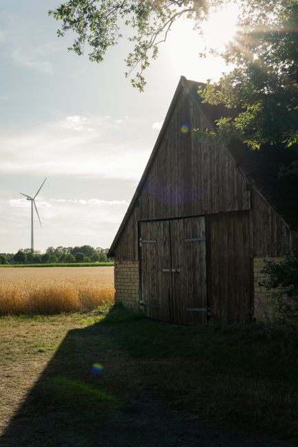 Quaint barn with wind turbine in a sunny rural landscape in Gescher, Germany.