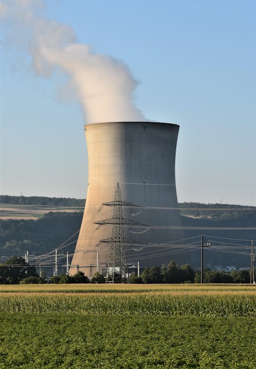 Foto profissional grátis de área industrial, campo de grama, céu azul