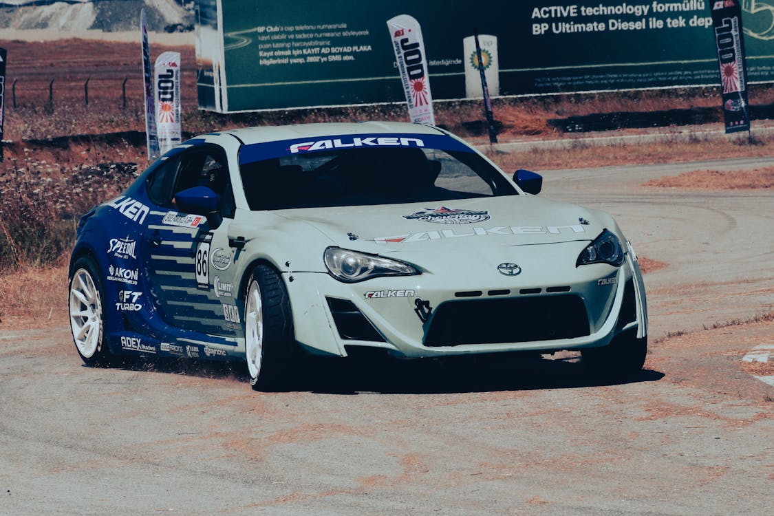 A White and Blue Racing Car on a Race Track · Free Stock Photo
