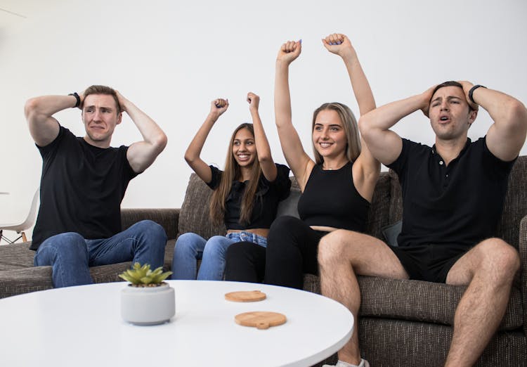 Friends Sitting On Couch Watching Sports