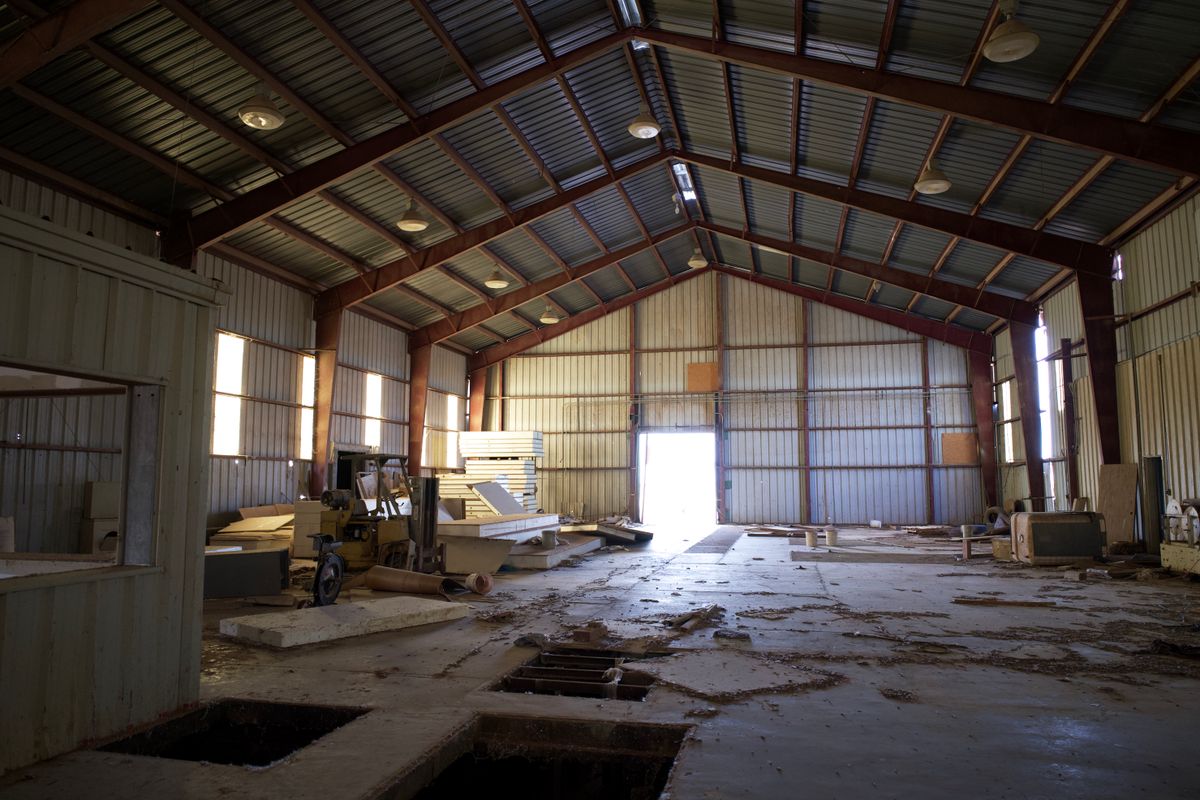 Empty warehouse interior lit through a far opening — photo by Strange Happenings on Pexels