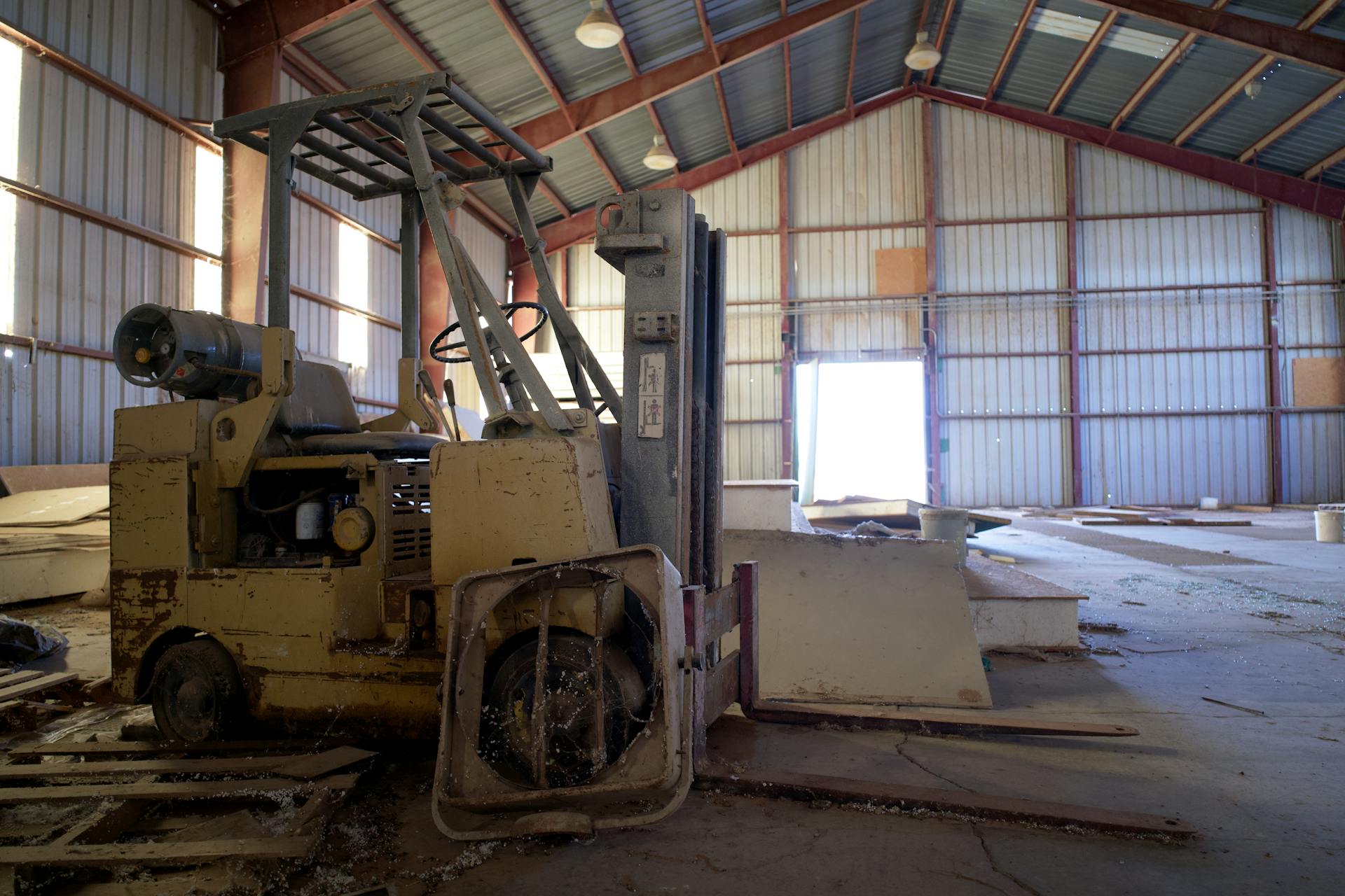 Interior view of an abandoned warehouse featuring a broken forklift in Arizona.