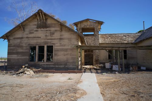 Free An abandoned wooden house with a decaying facade under a bright blue sky in California. Stock Photo
