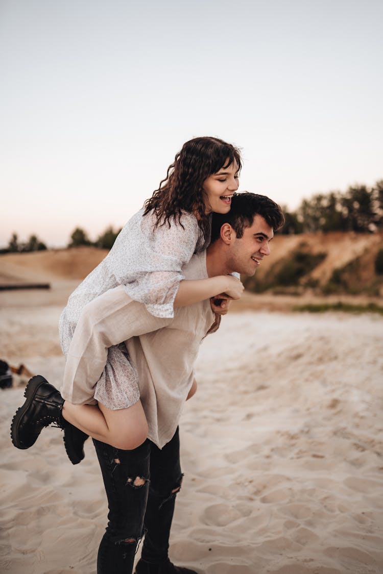 A Couple Walking On Brown Sand