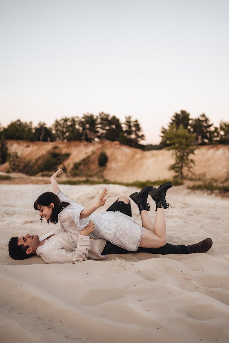 Woman Lying Down On Man On Beach