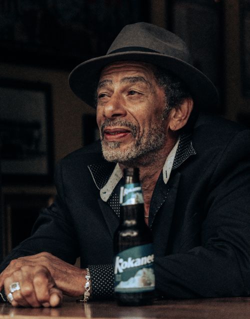 Free Elderly man in a hat enjoying a bottle of Kokanee beer inside a cozy Edmonton bar. Stock Photo
