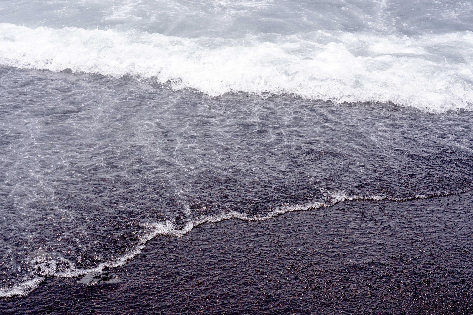 Vivid waves breaking on the unique black sand beach in Tenerife, capturing serene natural beauty.