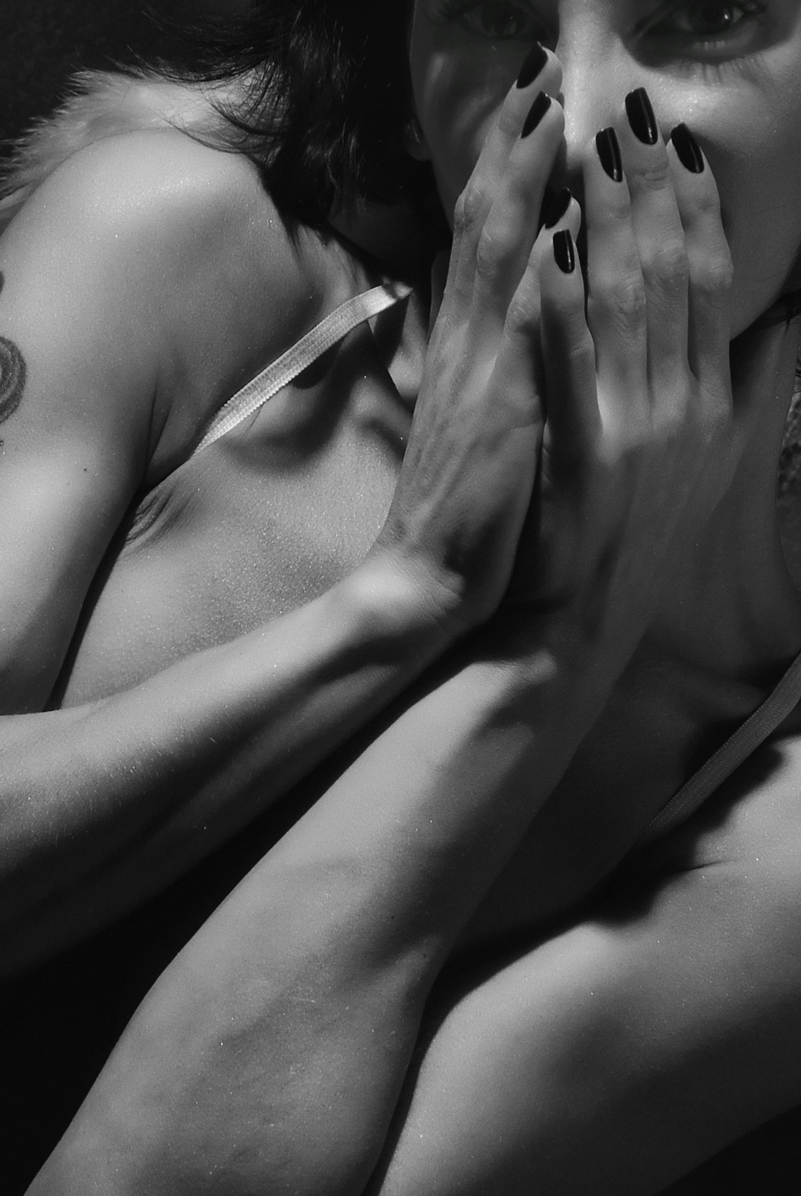 close up and grayscale photo of woman covering her mouth