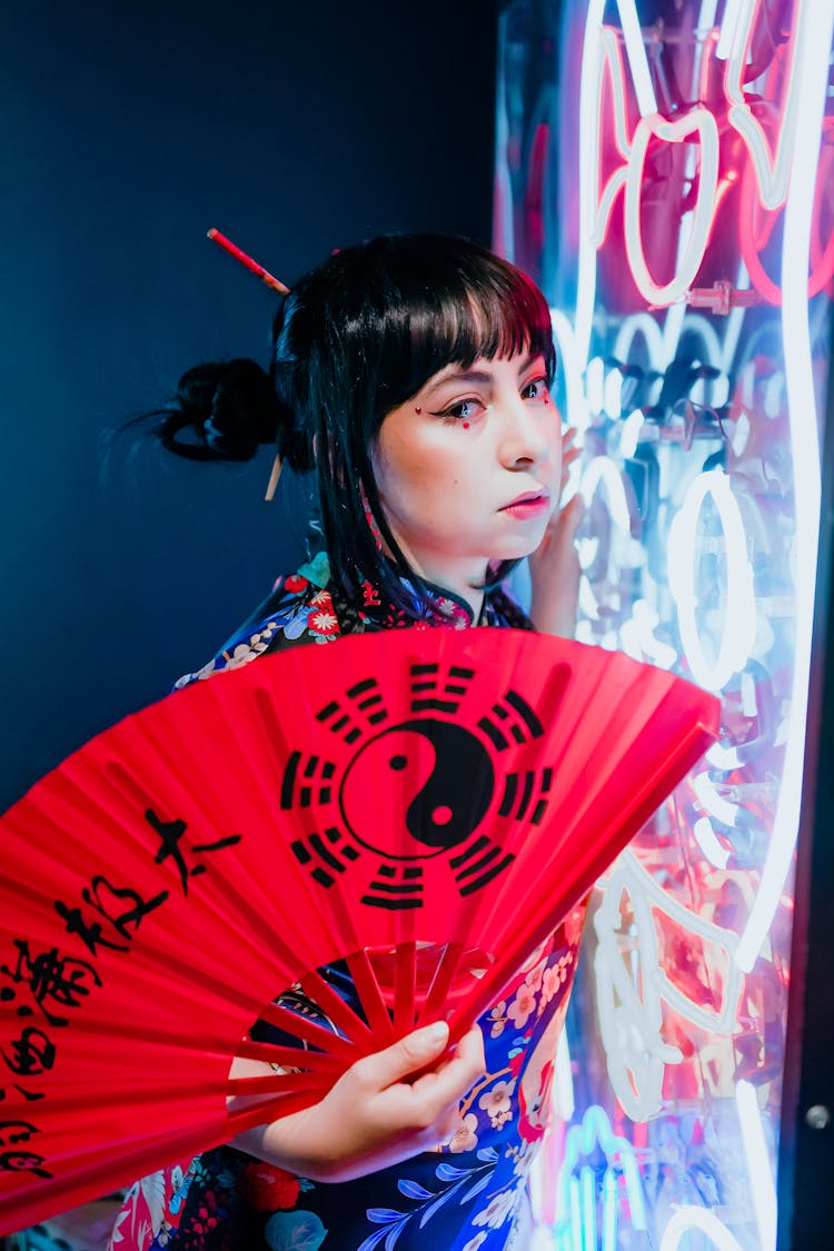 A Woman Holding Red Fan