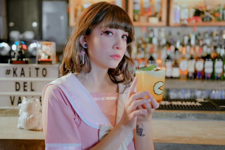 A Woman In Pink Top Holding A Glass Of Drink