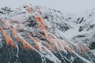 阳光照耀着白雪皑皑的山峰，景色令人惊叹，非常适合冒险和自然爱好者