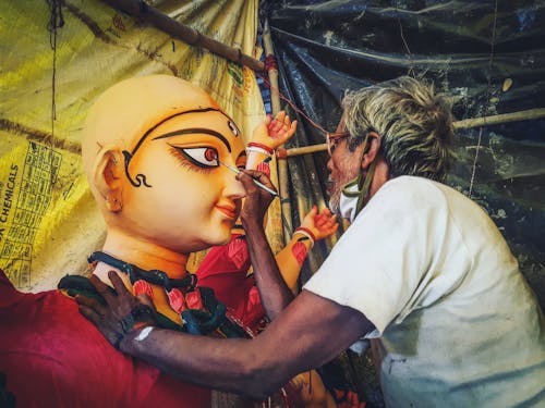 Elderly Artist Painting a Hindu Goddess Figure 